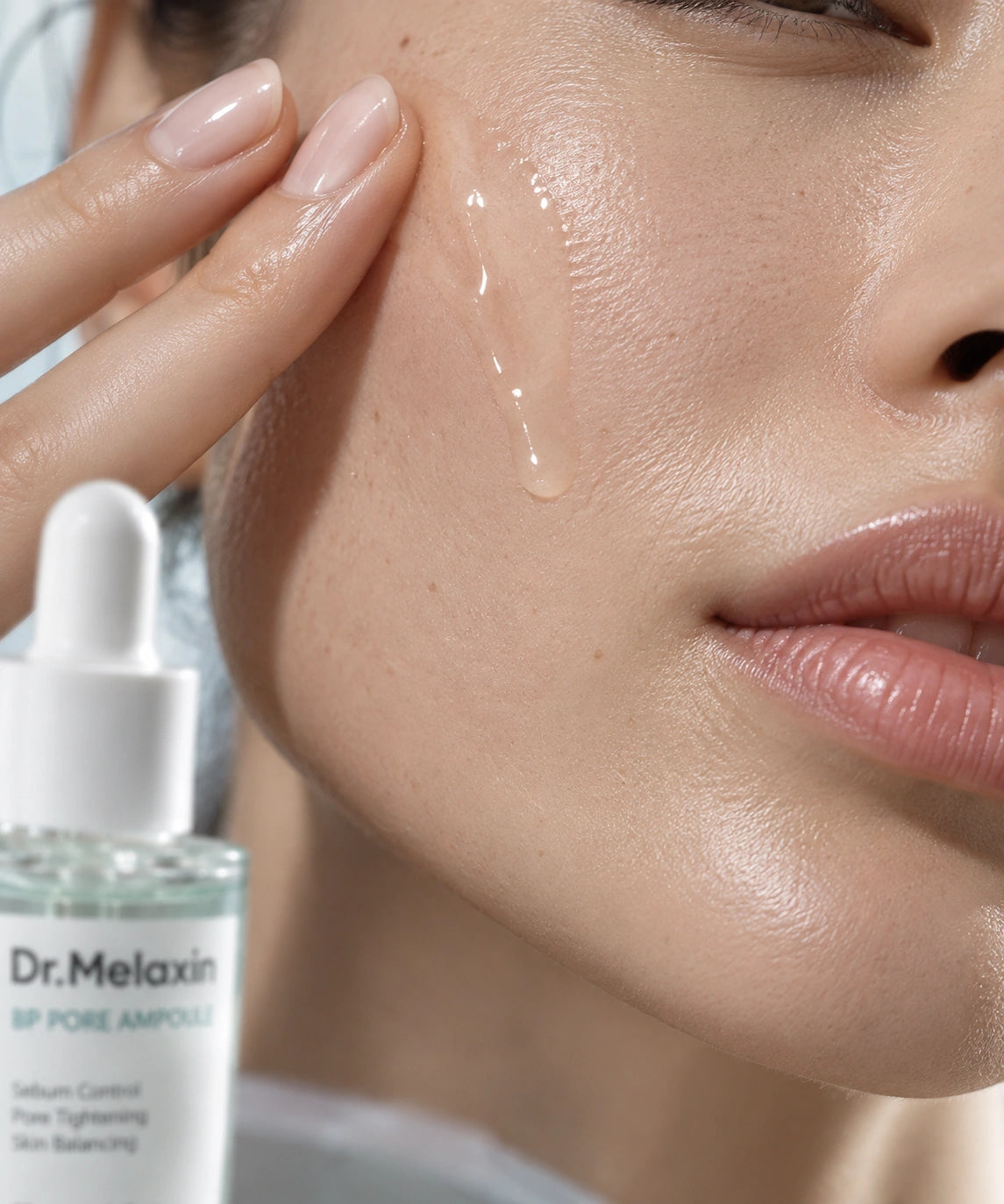 Dr. Melaxin BP Pore Ampoule áttetsző szérumának felvitele női arcbőrre közeli makrófotón