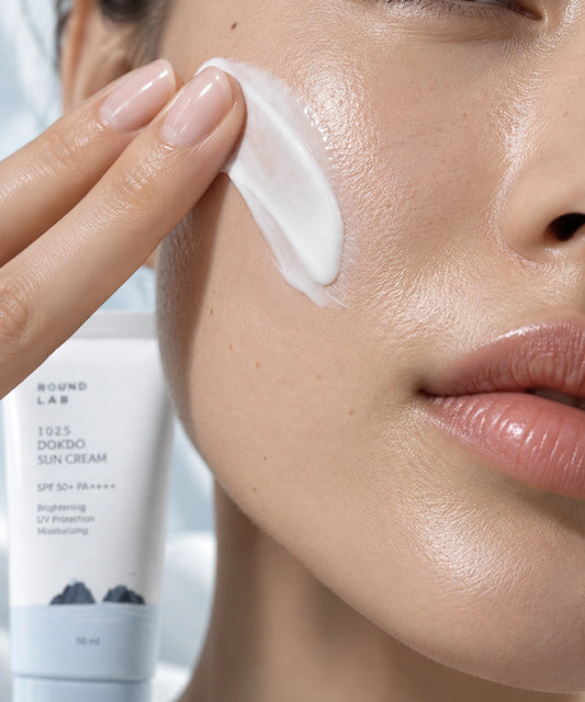 Round Lab 1025 Dokdo Sun Cream fényvédőkrém felvitele női orcára közeli beauty makrófotón